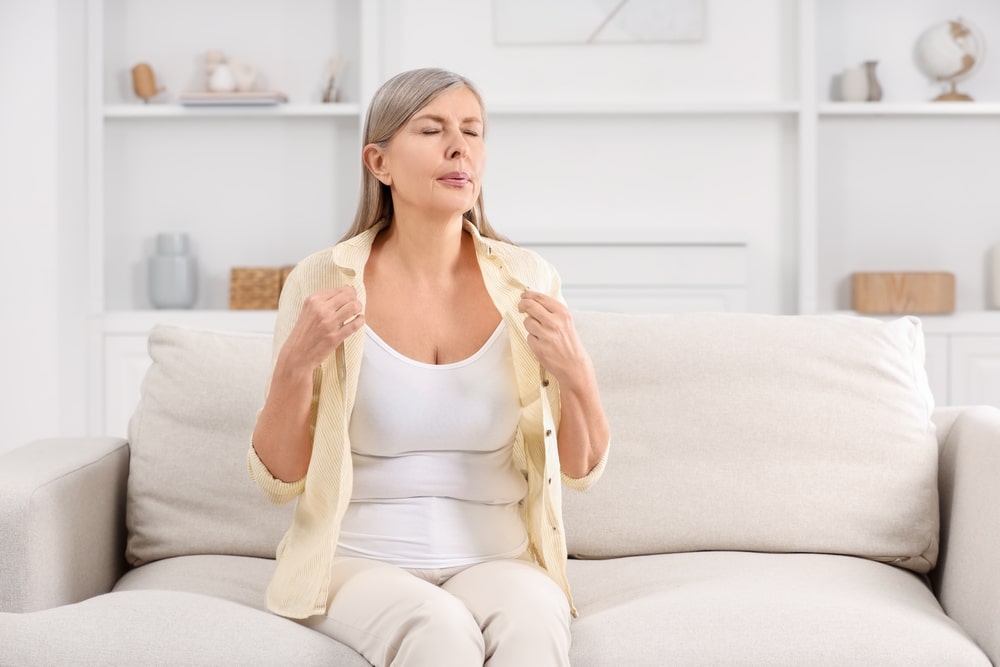 Menopause.,Woman,Suffering,From,Hot,Flash,On,Sofa,At,Home,